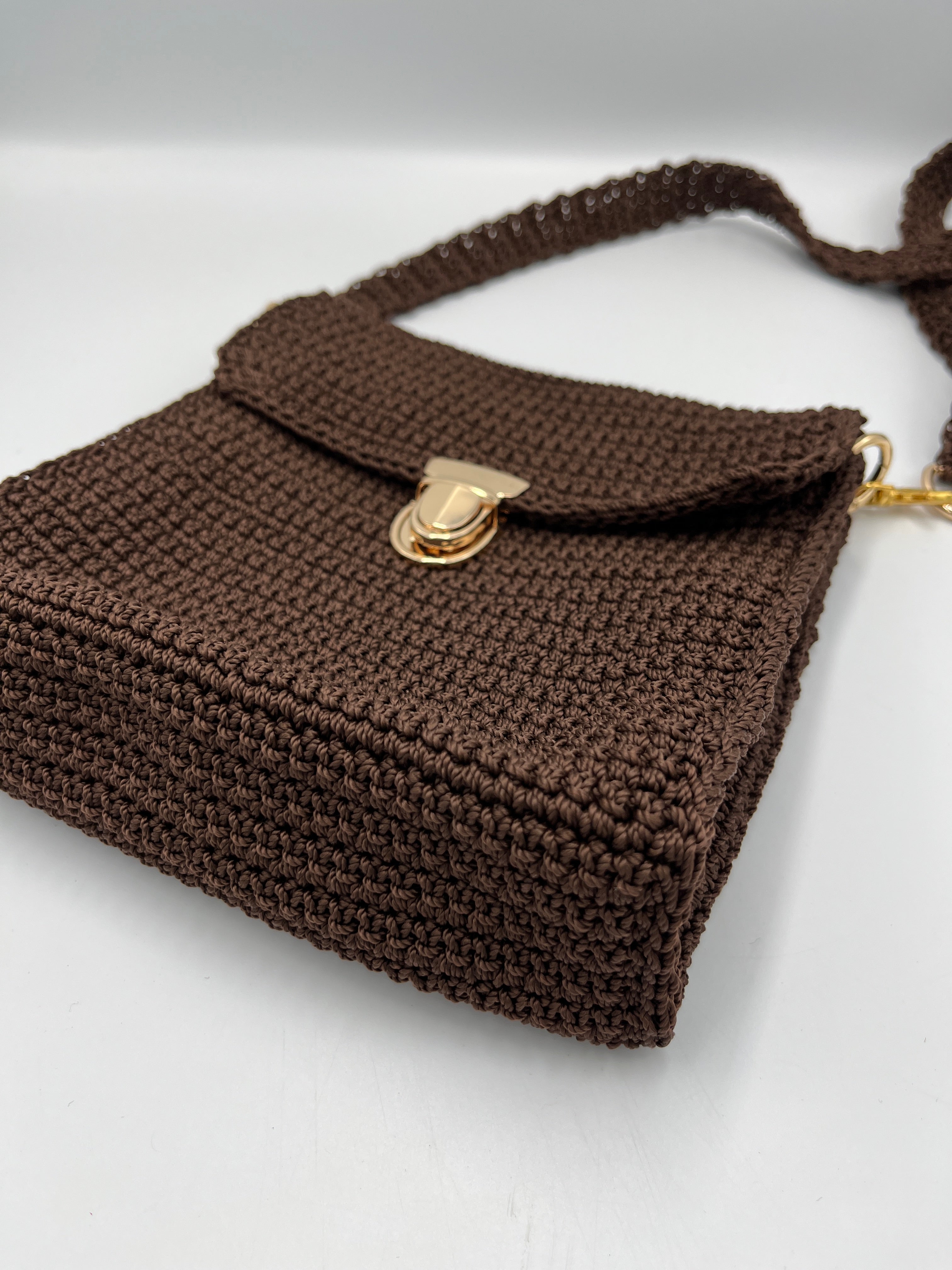 Bolso a crochet de tiro largo, elaborado en hilo de polipropileno con broche.